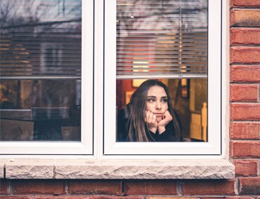 Sad girl staring out of window
