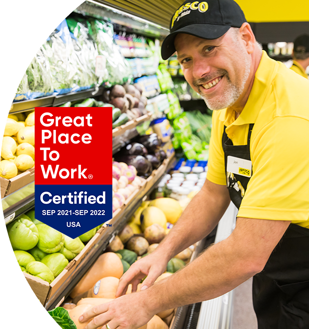 'Great Place to Work - Certified Sep 2021-Sep 2022' - Fresco Y Mas associate smiling and stocking produce