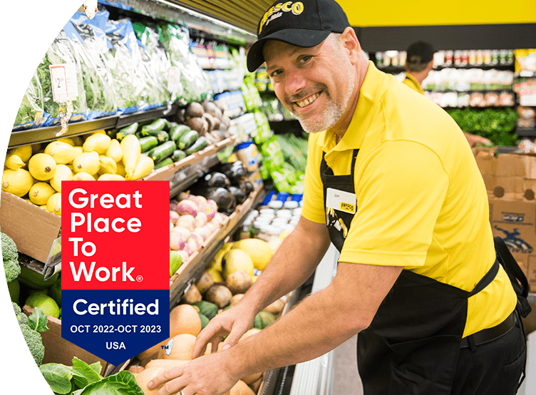 'Great Place to Work - Certified Oct 2022-Oct 2023' - Fresco Y Mas associate smiling and stocking produce