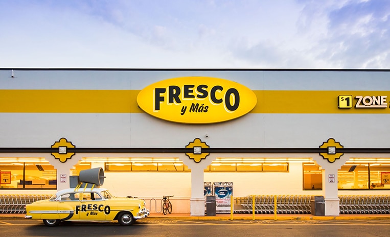 Taxi labeled 'Fresco Y Mas' parked in front of a Fresco Y Mas store